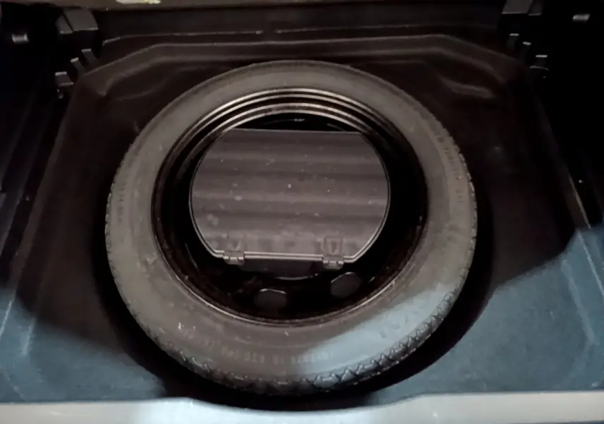 Vue rapprochée de la roue de secours noire dans le coffre du Citroën C5 Aircross gris foncé 2020.