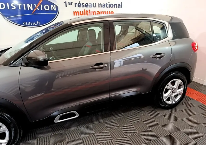 Vue de profil côté gauche d’un Citroën C5 Aircross gris foncé 2020 avec jantes alliage et vitres arrière surteintées.