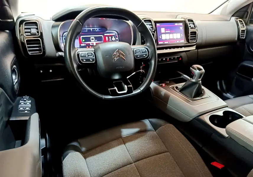 Vue intérieure côté conducteur du Citroën C5 Aircross 1.5 BlueHDi 130 avec volant cuir et levier de vitesse manuel.