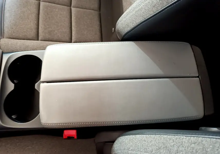 Vue rapprochée de l'accoudoir central gris clair et des sièges tissu gris dans une Citroën C5 Aircross 2020.