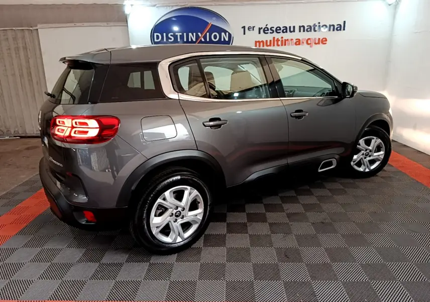 Vue 3/4 arrière droite d'un Citroën C5 Aircross gris foncé avec feux arrière LED et jantes alliage 17 pouces.