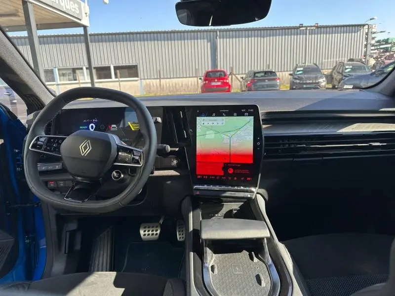 Vue intérieure avant du Renault Rafale 1.2 E-Tech 300ch esprit Alpine bleu, avec grand écran tactile central et volant multifonction.