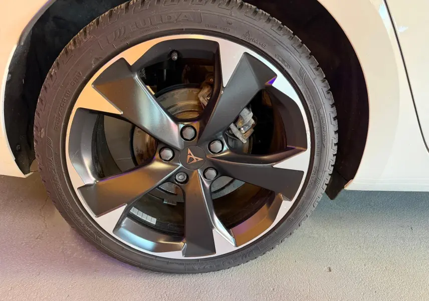 Gros plan sur la roue avant gauche blanche d'une CUPRA LEON ST 2024 avec jante noire et argentée au design moderne.