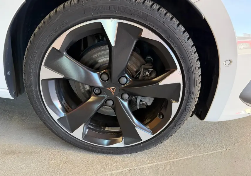 Gros plan sur la roue avant droite d'une CUPRA LEON ST blanche, avec jante alliage noire et argentée au design moderne.