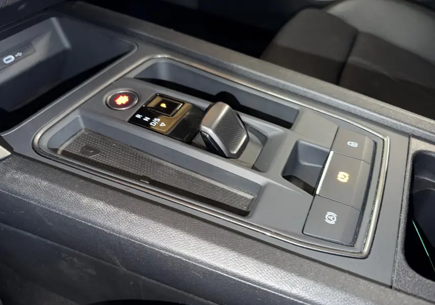 Vue rapprochée de la console centrale noire du CUPRA LEON ST 2024 avec levier de boîte automatique et boutons lumineux.
