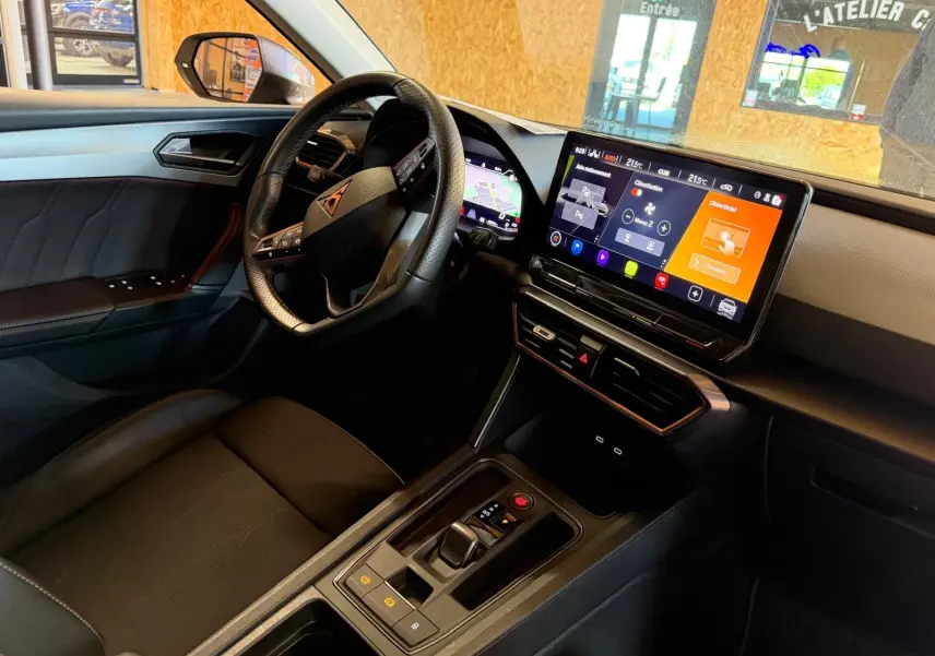 Vue intérieure côté conducteur de la CUPRA LEON ST 2024 avec tableau de bord numérique et écran tactile central.