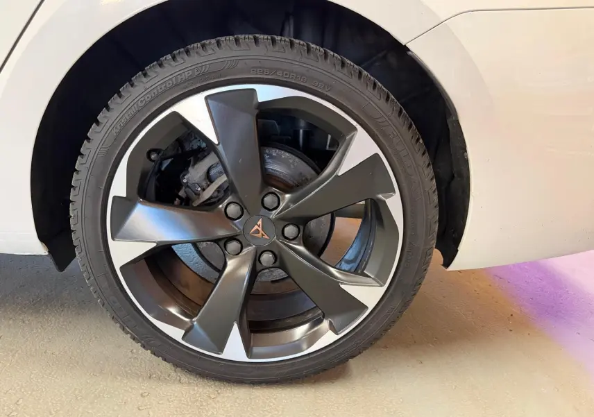 Gros plan sur la roue avant droite blanche d'une CUPRA LEON ST 2024 avec jante alliage bicolore et logo CUPRA central.