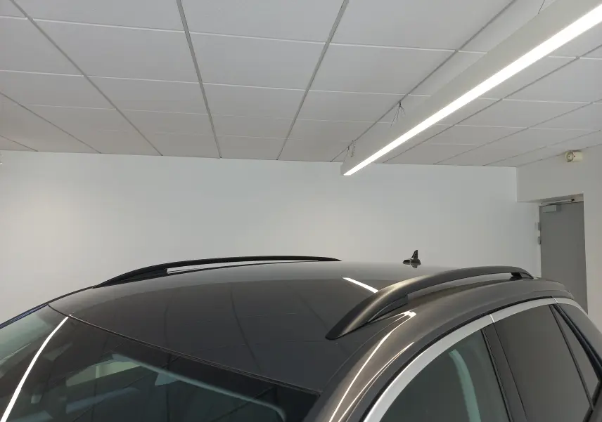 Vue rapprochée du toit gris indium du Volkswagen T-Roc 2025, avec barres de toit noires et antenne requin.