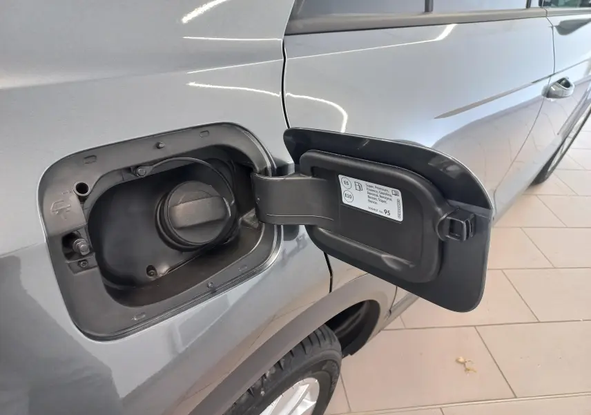 Vue rapprochée de la trappe à carburant ouverte côté gauche du Volkswagen T-Roc gris Indium 2025.