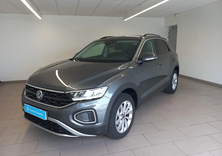 Volkswagen T-Roc 1.5 TSI 150 DSG7 VW Edition gris Indium, vue 3/4 avant droit en intérieur showroom.