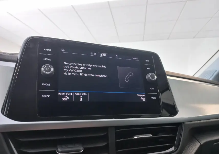 Écran tactile central du Volkswagen T-Roc 2025 affichant les options téléphone et réglages dans un intérieur moderne.