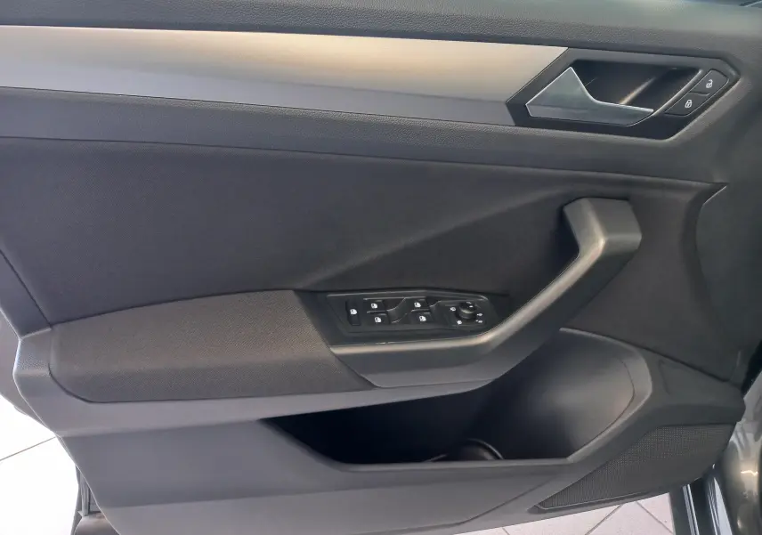 Gros plan sur la porte intérieure côté conducteur du Volkswagen T-Roc 2025, avec commandes de vitres et serrure visibles.