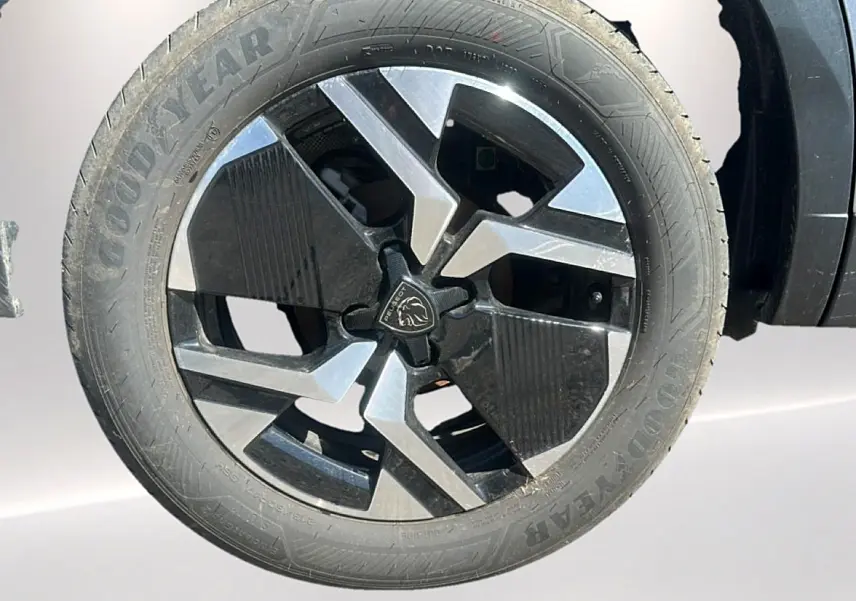Gros plan sur la jante alu bicolore noire et argent du côté avant droit du Peugeot 2008 gris artense.