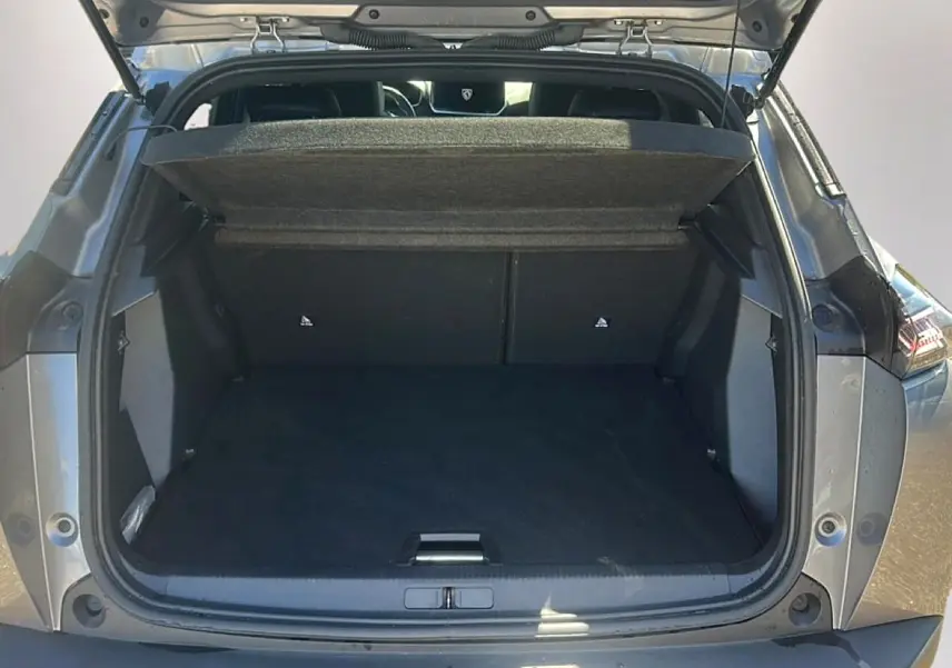 Coffre ouvert vu de l'arrière d'un Peugeot 2008 gris artense, montrant l'espace de chargement et la tablette cache-bagages.