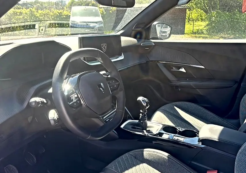 Intérieur de la Peugeot 2008 1.2 100 Allure, vue côté conducteur, volant compact et écran tactile central.