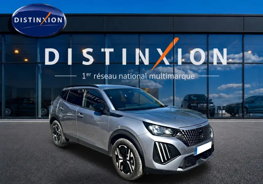 Peugeot 2008 gris artense en 3/4 avant droit, avec calandre verticale et jantes alliage noires et argentées.