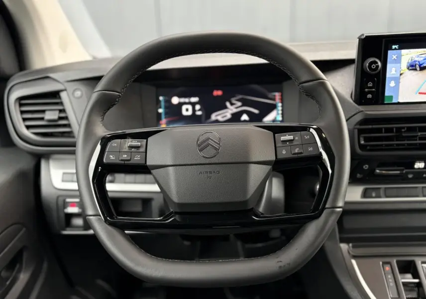 Vue rapprochée du volant noir de la Citroën Jumpy 2026 avec commandes intégrées et écran tactile en arrière-plan.