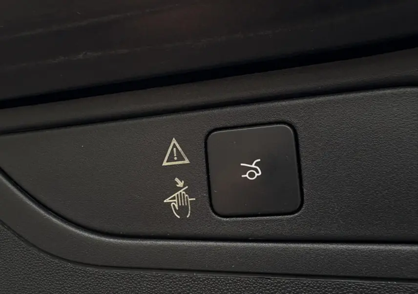 Bouton noir de hayon électrique avec pictogramme blanc, sur panneau intérieur du Citroën C4 Spacetourer gris foncé.