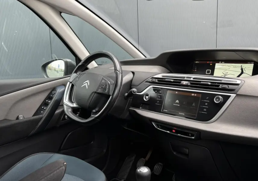 Intérieur avant gauche du Citroën C4 Spacetourer gris foncé, volant cuir, tableau de bord avec écran tactile et navigation.