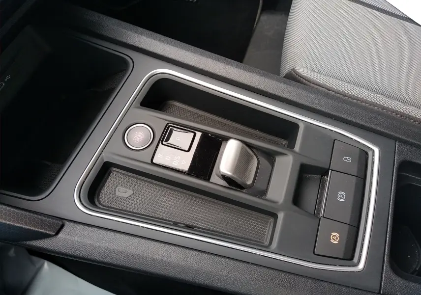 Vue rapprochée de la console centrale grise de la SEAT LEON ST 2022, avec levier de boîte auto et boutons de commande.