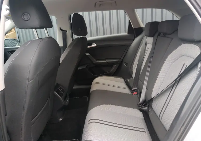 Vue intérieure côté droit des sièges arrière en tissu gris et noir de la SEAT LEON ST 2022, avec ceinture de sécurité visible.