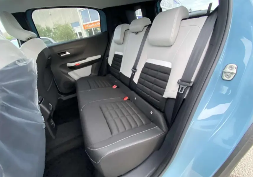 Vue intérieure côté arrière droit du Citroën C3 Aircross 2025 bleu Monte Carlo, montrant la banquette bicolore noire et grise.