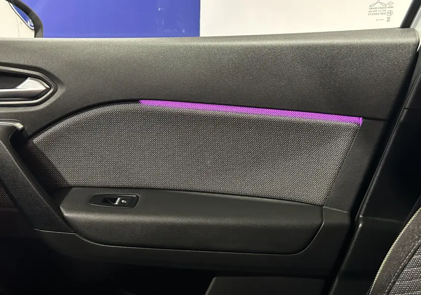 Détail de la porte côté droit du Renault Symbioz blanc nacré 2025 avec éclairage d'ambiance violet et bouton de fenêtre.