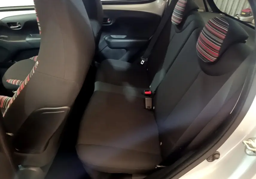 Vue intérieure côté droit sur la banquette arrière noire avec appuie-têtes rayés d'une Citroën C1 gris clair 2019.