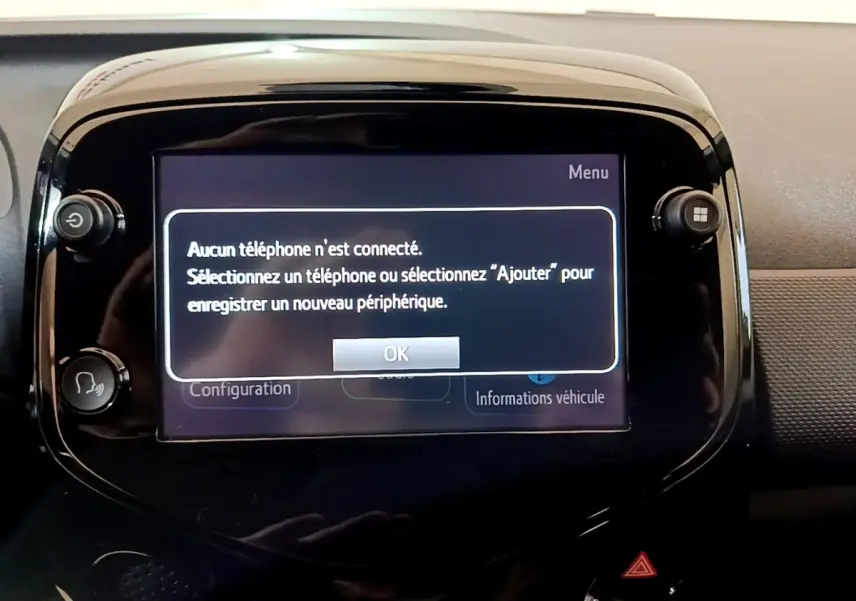 Écran tactile central de la Citroën C1 gris clair, affichant un message de connexion téléphone dans l'habitacle.