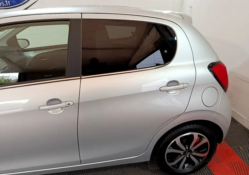 Profil droit de la Citroën C1 gris clair 2019, mettant en valeur les vitres teintées et les jantes noires distinctives.
