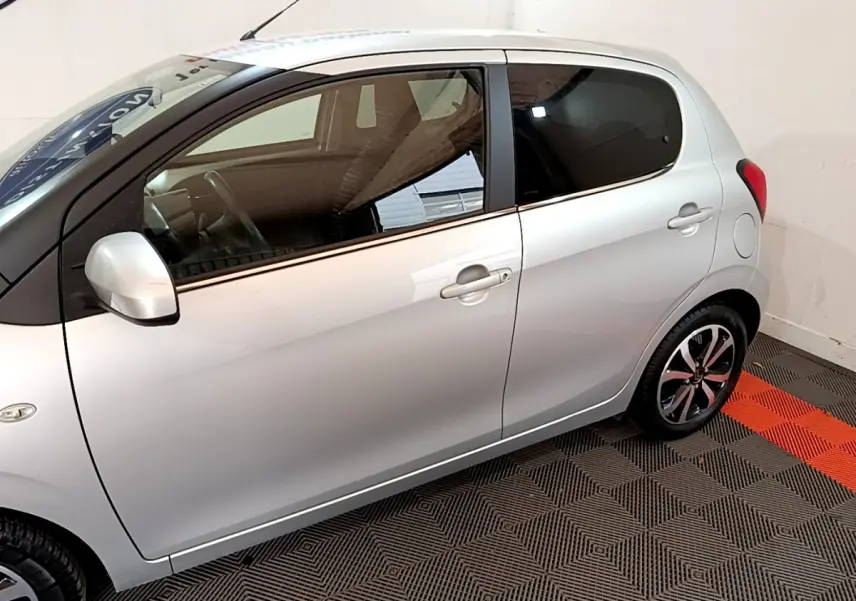 Profil côté gauche d'une Citroën C1 gris clair 2019, avec jantes alliage et vitres arrière teintées.