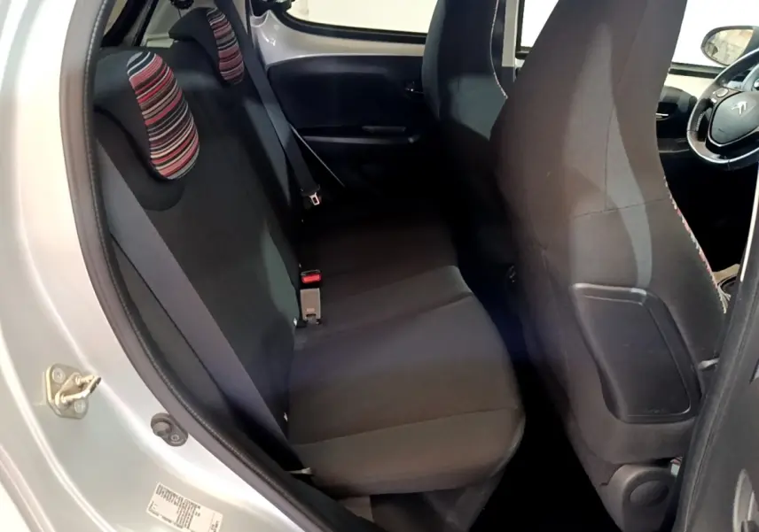 Vue intérieure côté gauche sur la banquette arrière noire avec appuie-têtes rayés d'une Citroën C1 gris clair 2019.