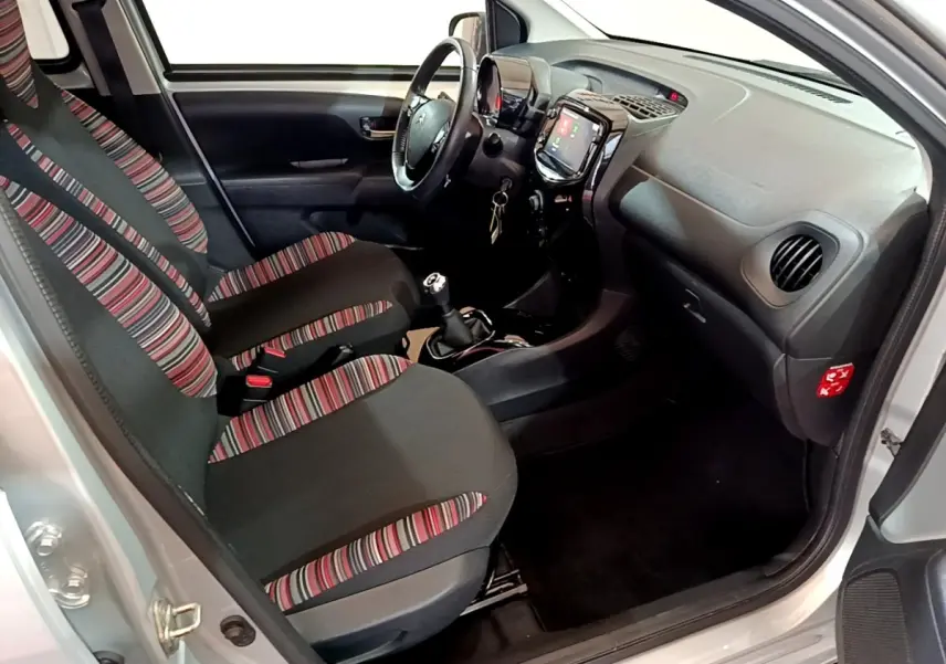Intérieur avant droit de Citroën C1 gris clair 2019, sièges à motifs rayés et tableau de bord avec écran tactile.