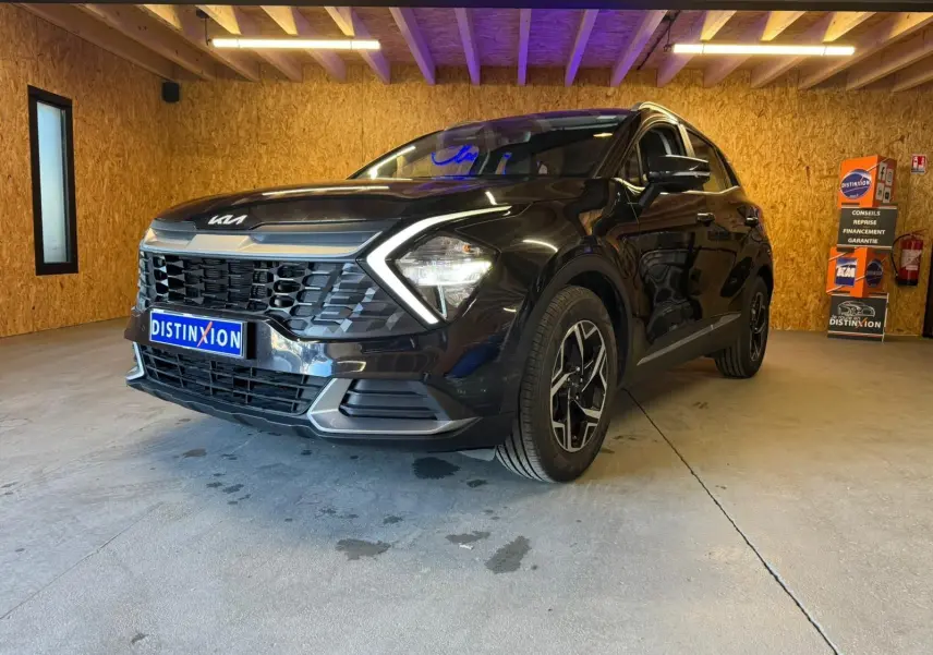 KIA SPORTAGE noir en 3/4 avant droit, mettant en valeur sa calandre distinctive et ses phares LED angulaires.