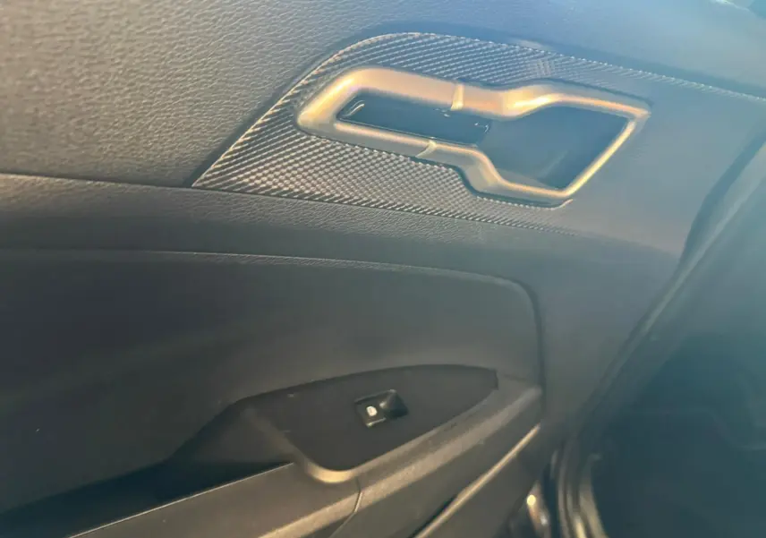 Poignée intérieure et commande de lève-vitre côté droit de la porte noire du Kia Sportage 2022 diesel hybride.