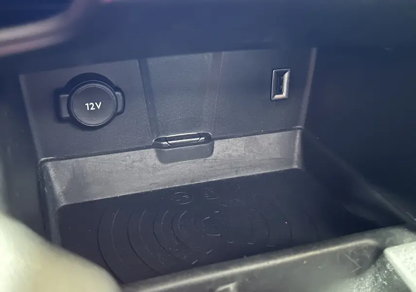 Gros plan sur la console centrale du DS7 Crossback 2022, montrant prise 12V, port USB et zone de charge sans fil noire.
