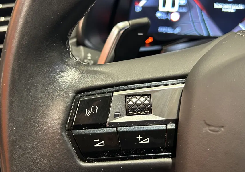 Gros plan sur les commandes de volume et de voix au volant cuir noir du DS7 Crossback 2022 couleur Cristal Pearl.