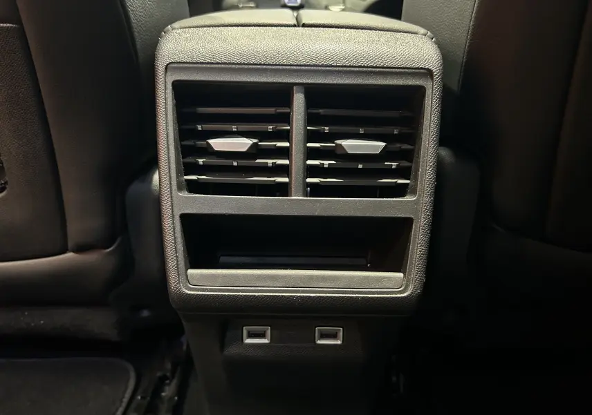 Vue rapprochée des aérateurs arrière et ports USB noirs du DS7 Crossback 2022 dans un intérieur sombre.