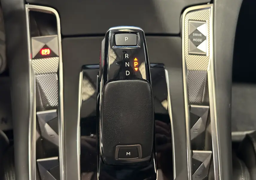 Gros plan sur la commande de boîte automatique noire du DS7 Crossback, avec boutons latéraux en finition argentée texturée.