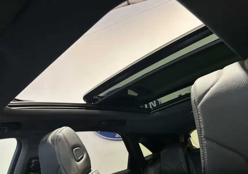 Vue intérieure du toit ouvrant panoramique du DS7 Crossback avec sièges en cuir gris visibles au premier plan.