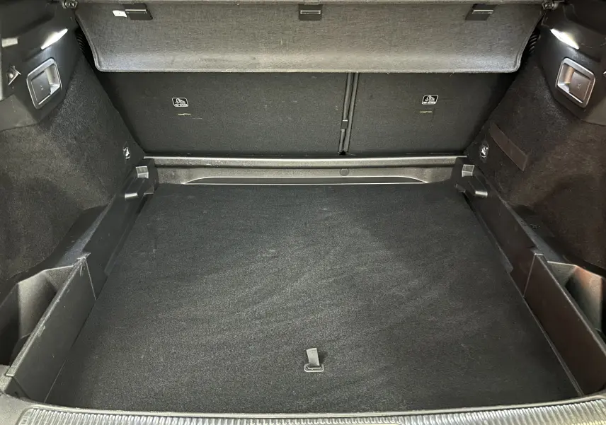 Vue intérieure du coffre spacieux et propre du DS7 Crossback 2022, revêtement noir et finitions soignées.
