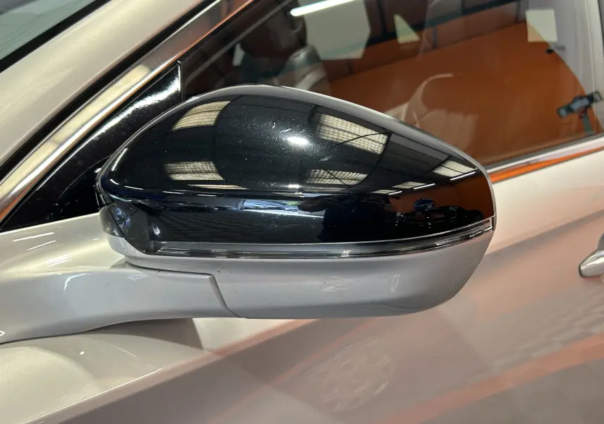 Rétroviseur noir brillant côté gauche du DS7 Crossback Cristal Pearl, avec reflet intérieur et carrosserie claire visible.