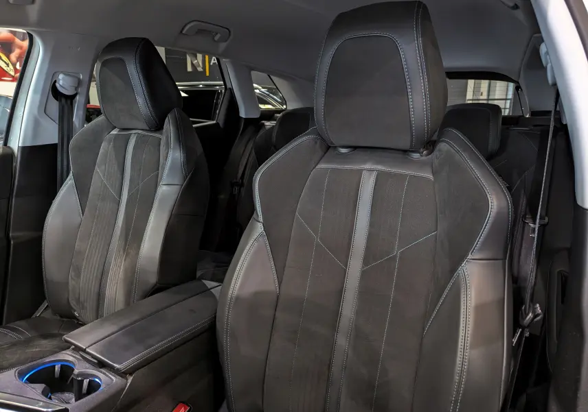 Gros plan sur les sièges avant en cuir noir avec surpiqûres bleues du Peugeot 3008 Crossway 2018.