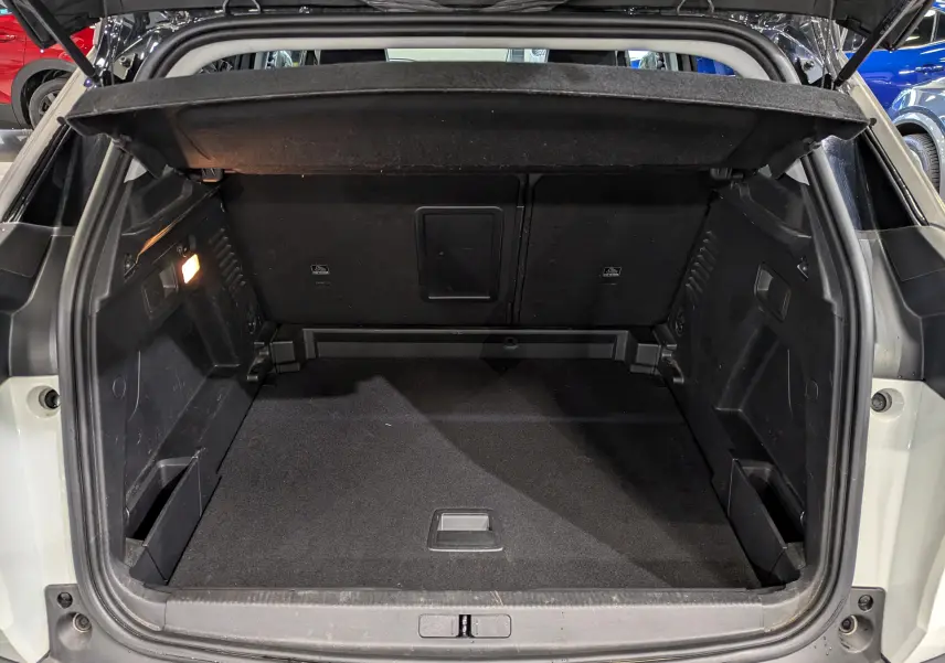 Coffre ouvert du Peugeot 3008 blanc Glacier avec toit noir, vue arrière montrant l'espace de chargement vide et l'éclairage intérieur.