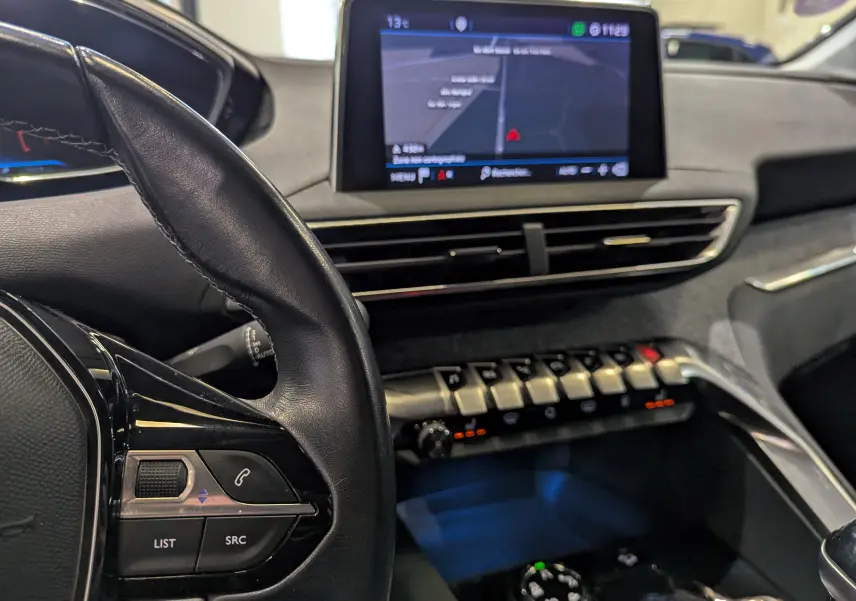 Vue rapprochée de l'intérieur du Peugeot 3008 2018, montrant le volant, l'écran tactile et les commandes centrales.