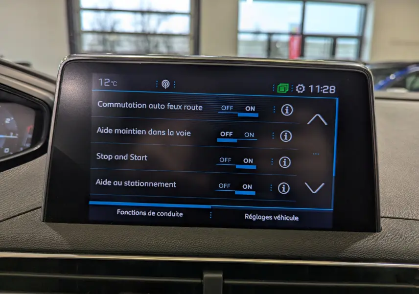 Écran tactile central du Peugeot 3008 blanc Glacier avec toit noir affichant les réglages d'aides à la conduite.