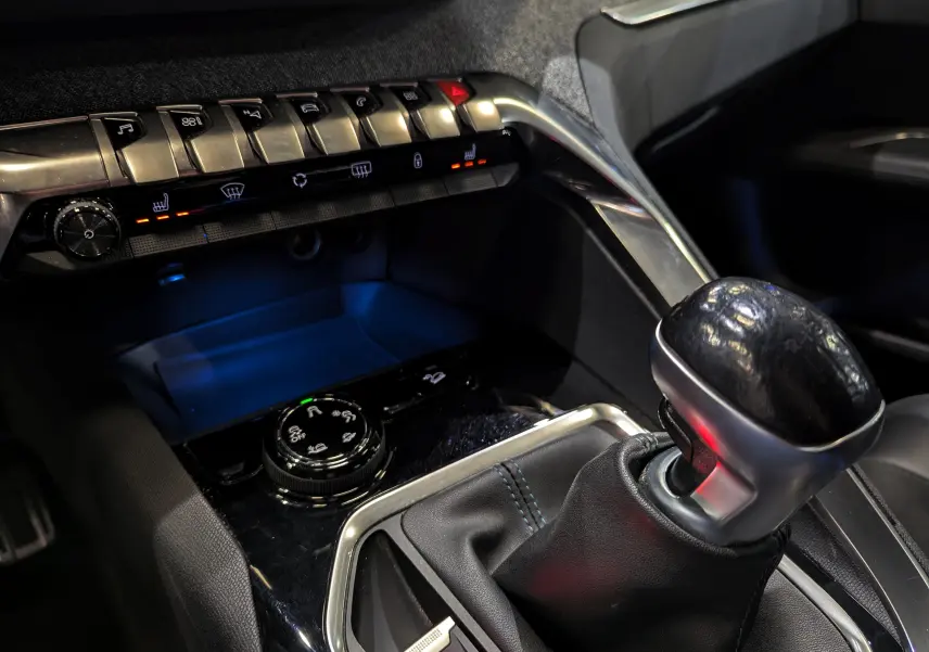 Gros plan sur la console centrale du Peugeot 3008 2018, mettant en valeur le levier de vitesse manuel et les commandes de climatisation.
