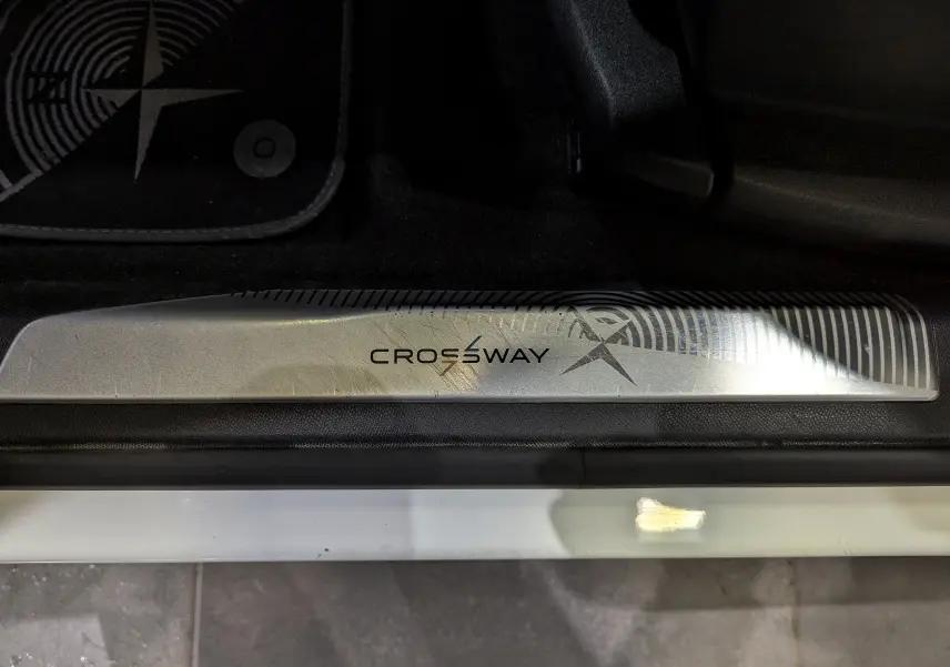Gros plan sur la plaque de seuil côté gauche marquée Crossway du Peugeot 3008 blanc Glacier avec toit noir.