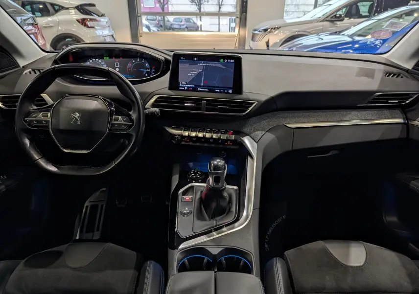 Vue intérieure frontale du tableau de bord et volant du Peugeot 3008 1.2 PureTech 2018 avec écran tactile et levier de vitesses manuel.