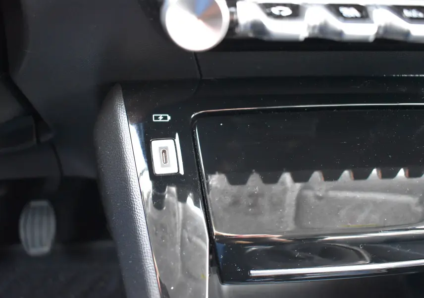 Gros plan sur la prise USB et la console noire brillante du Peugeot 2008 bleu diesel version Allure 2021.